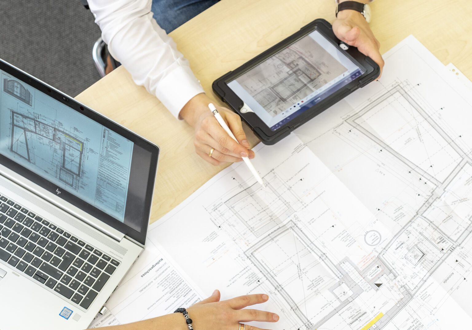 1060_020_AUSWAHL_05-Motiv_Equipment-6x7-1-1536x1075.2-c-default Architekten überprüfen Blaupausen und digitale Baupläne auf Laptop und Tablet.