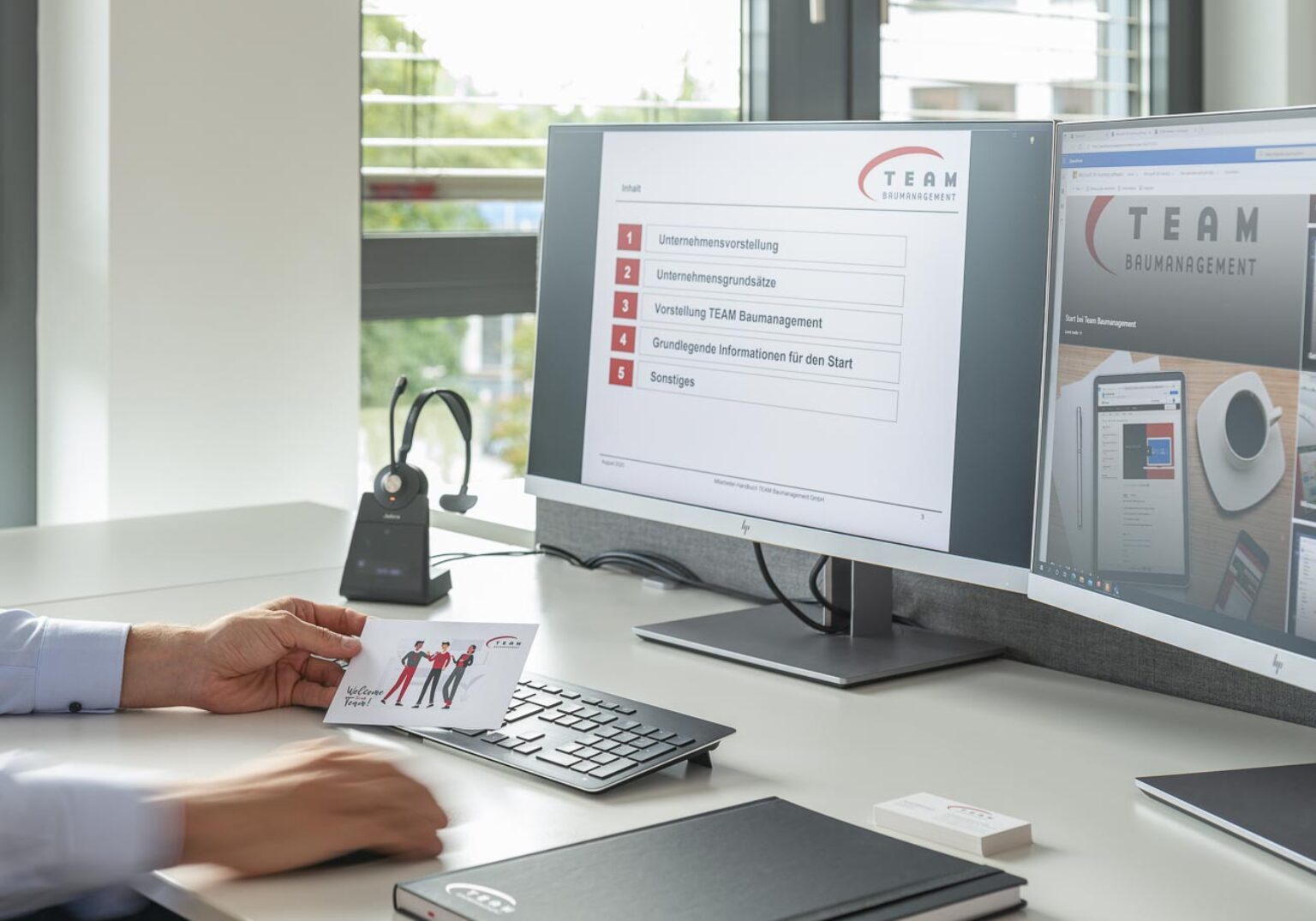 1790_01-1536x1075.2-c-default Mitarbeiter arbeitet am Schreibtisch mit zwei Monitoren und Computerausrüstung in einem modernen Büro.