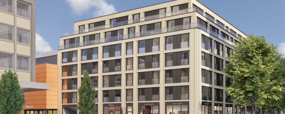 Moderne Stadtecke mit mehrstöckigem Gebäude, Geschäften und belebter Straße bei sonnigem Wetter.