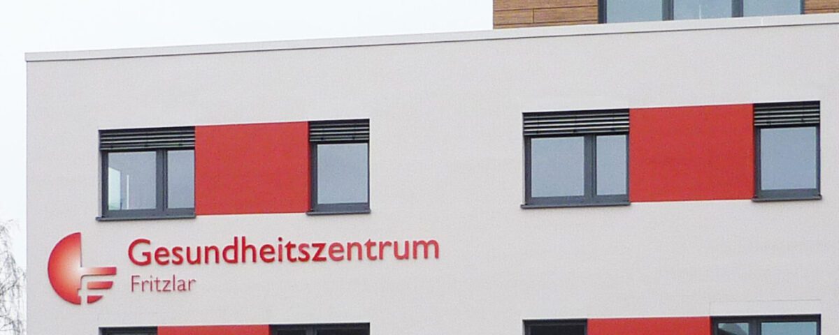 Fassade des Gesundheitszentrums Fritzlar mit modernen Fenstern und markanten roten Akzenten.