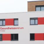 Fassade des Gesundheitszentrums Fritzlar mit modernen Fenstern und markanten roten Akzenten.
