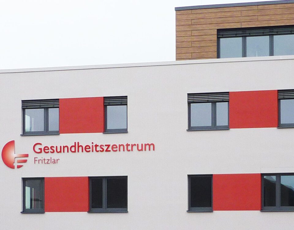 Fassade des Gesundheitszentrums Fritzlar mit modernen Fenstern und markanten roten Akzenten.