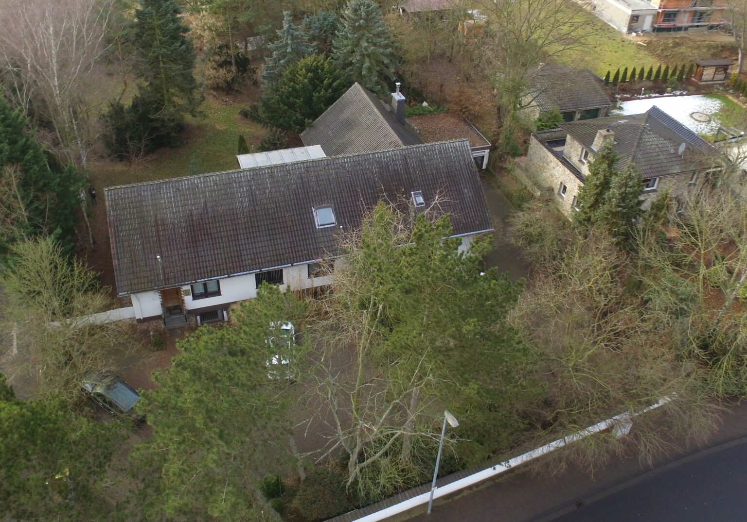 F_Albrecht-5-e1716547728149-1536x1075.2-c-default Luftaufnahme eines Hauses mit Garten, umgeben von Bäumen, in einem Wohngebiet.