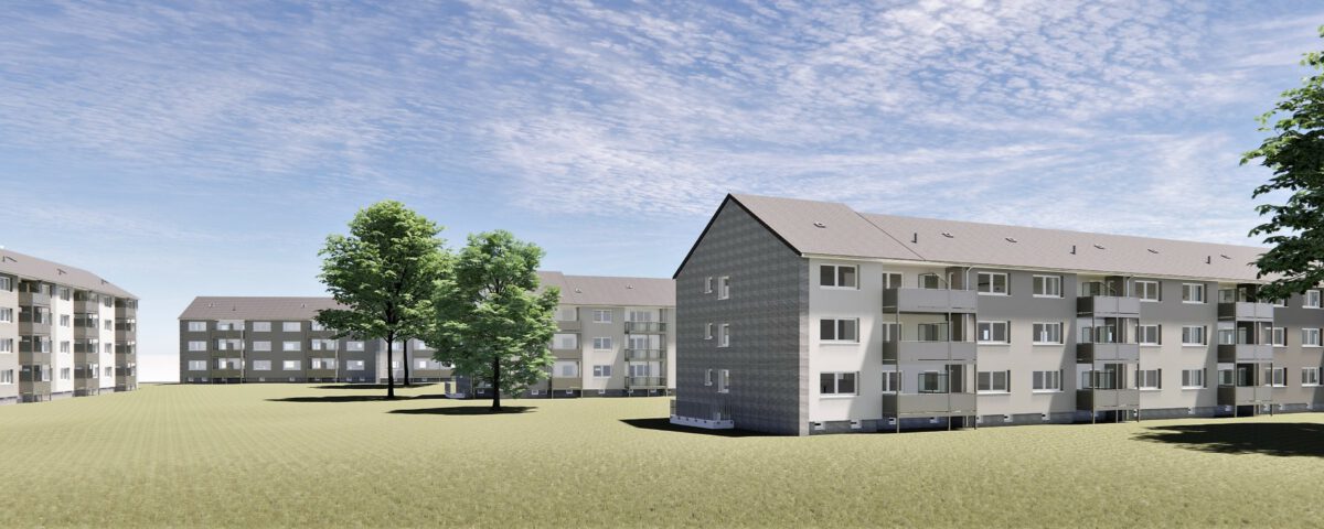 Moderne Mehrfamilienhäuser mit Balkonen, umgeben von Bäumen und Wiesen unter blauem Himmel.