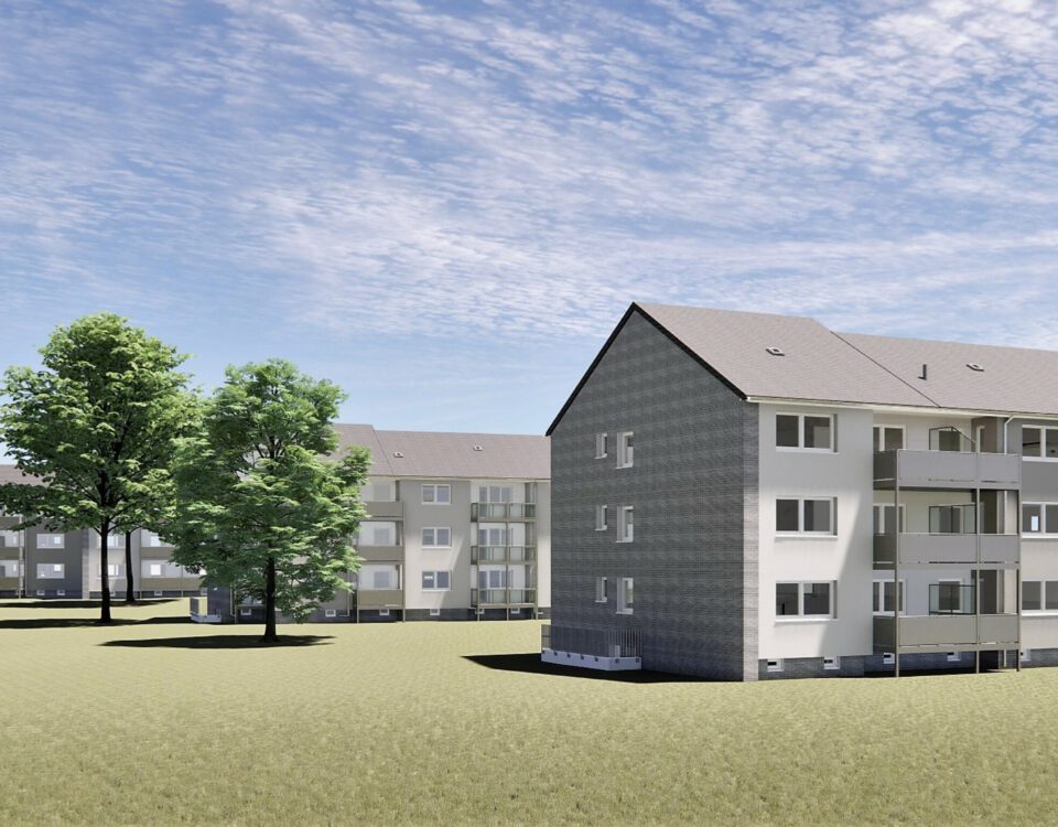 Moderne Mehrfamilienhäuser mit Balkonen, umgeben von Bäumen und Wiesen unter blauem Himmel.