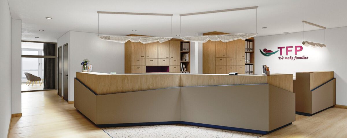 Moderne Empfangstheke mit TFP-Branding in hellem Bürogebäude, mit minimalistischer Holzoptik und einladender Atmosphäre.