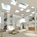 Modernes, lichtdurchflutetes Atrium mit Wendeltreppe, minimalistischen Sitzgelegenheiten und Personen im Gespräch.